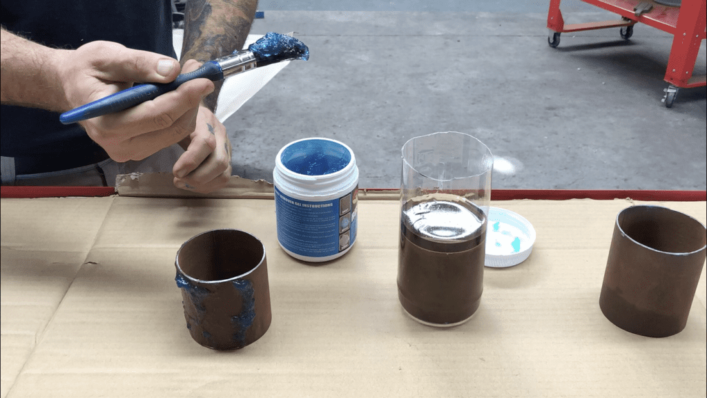 Applying  rust remover gel to a steel pipe